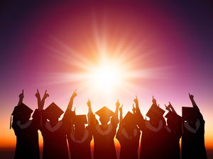 graduates in silhouette with sun setting behind them